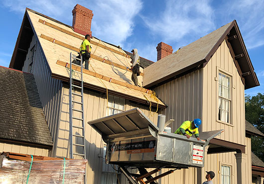 Progress photo of the Red Feather Group team working on the cedar shake re-roofing project for the Glenview Park District.